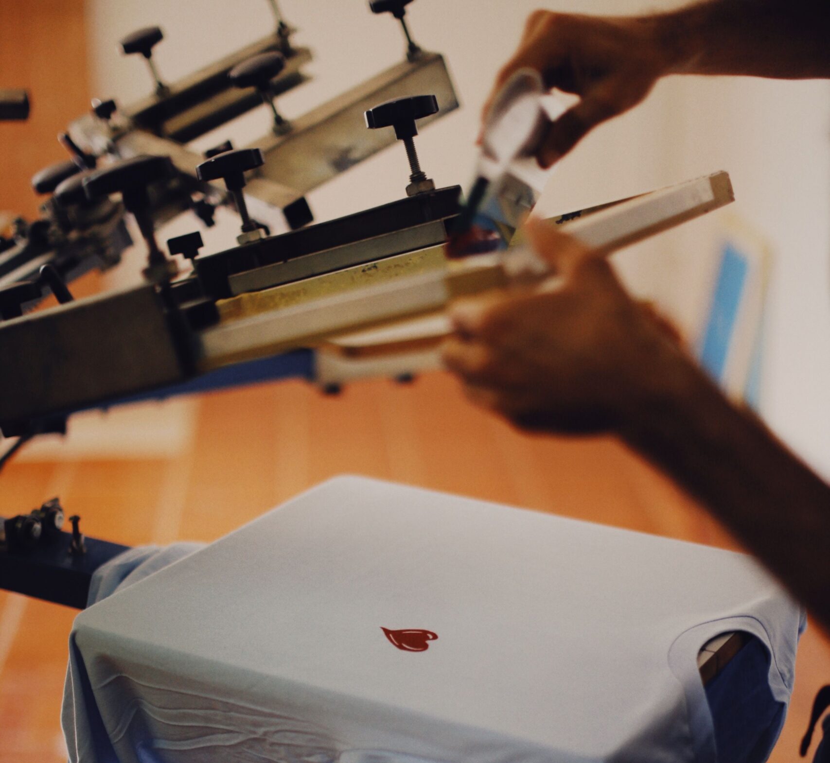 Impression & Communication visuelle Close-up of a man using a T-shirt printing machine indoors.